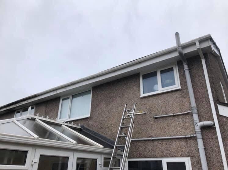 Gutter clearance in progress — vacuum system removing debris